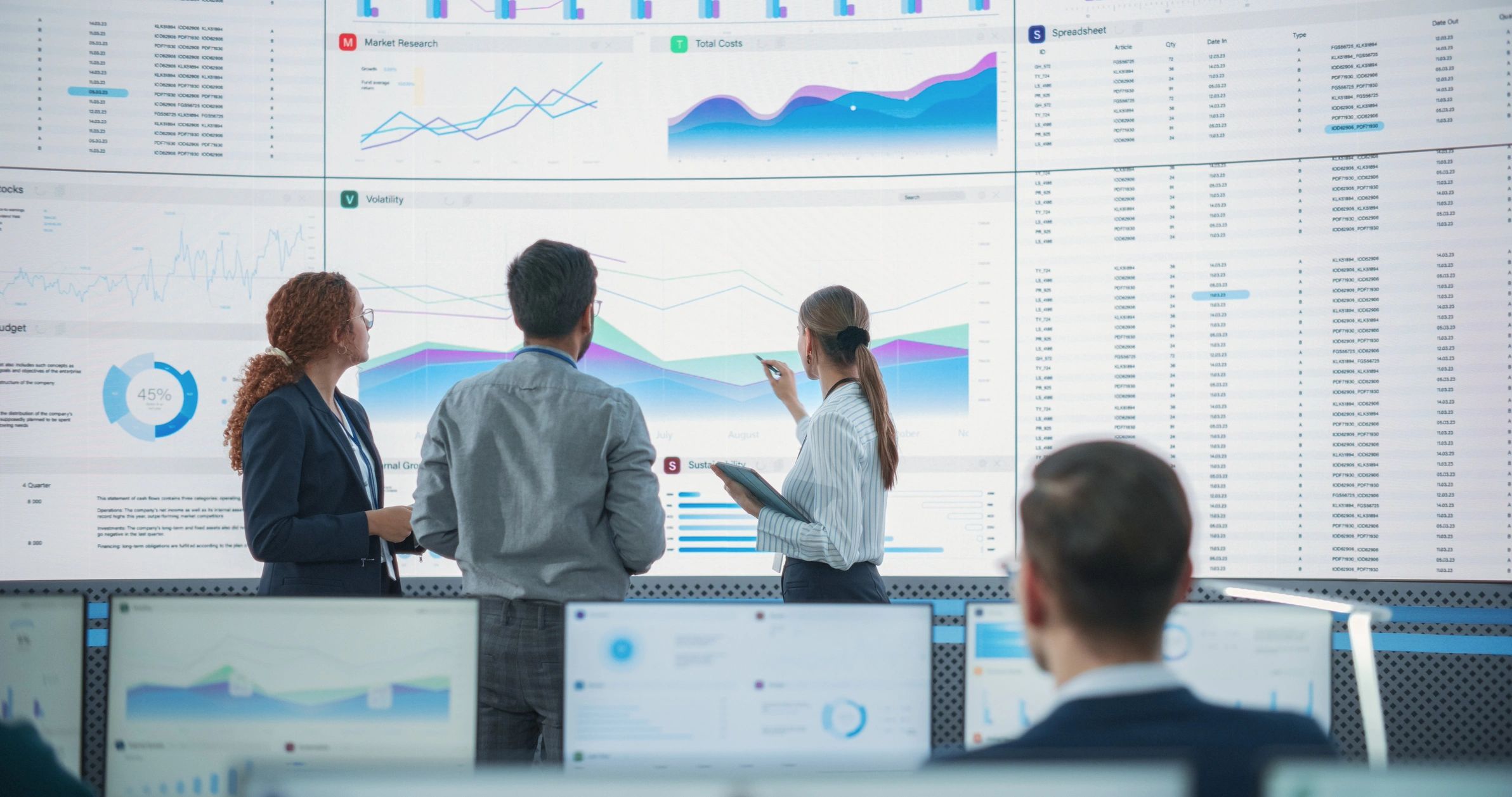 Team reviewing analytics dashboards on a large screen in a professional office