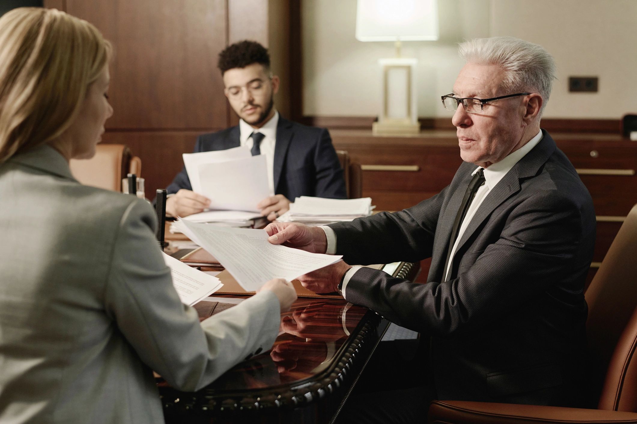 Legal professionals reviewing documents together in a boardroom